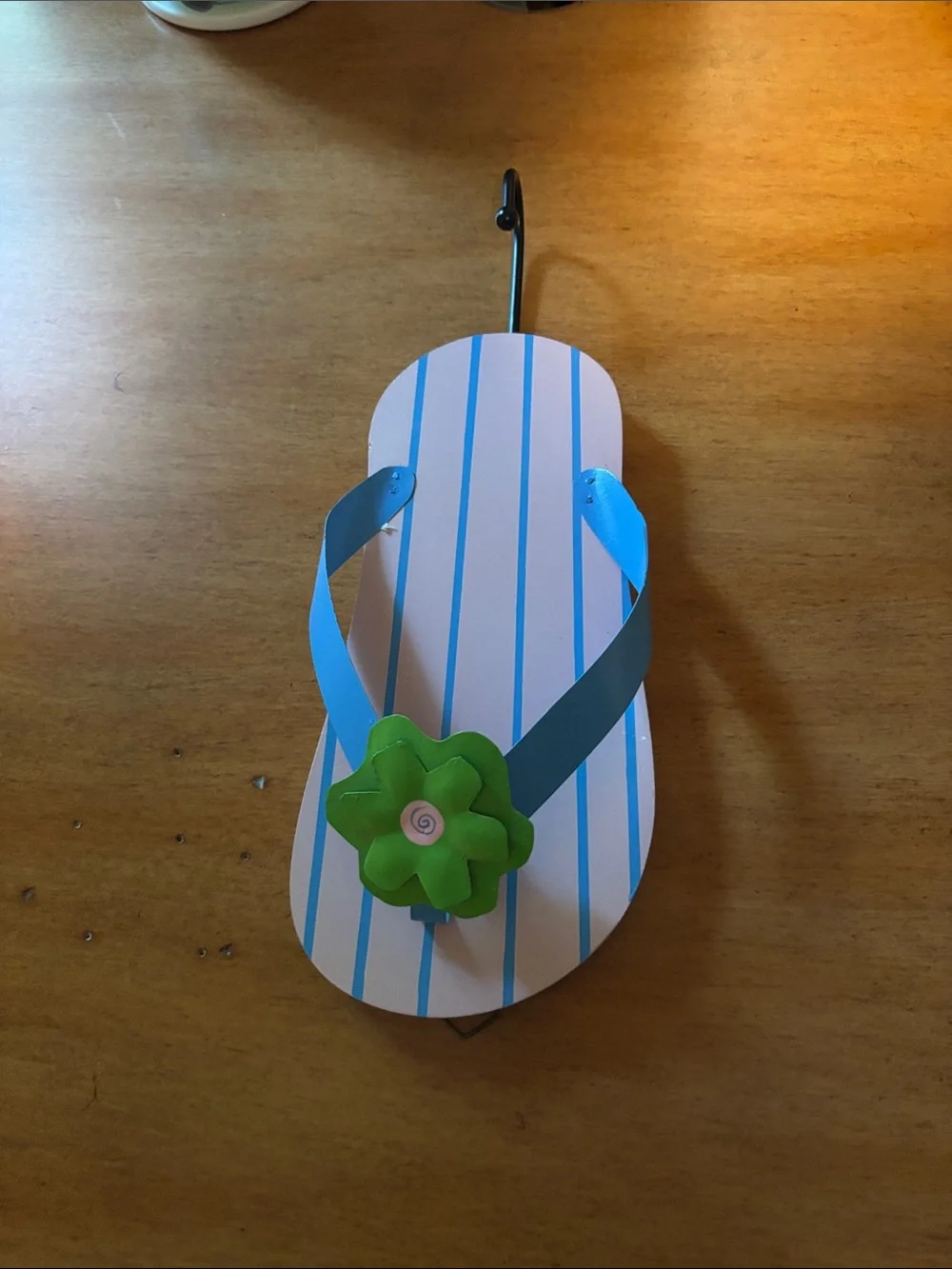 Kids Blue Striped Flip-Flops with Green Flower Accent wall hanger.